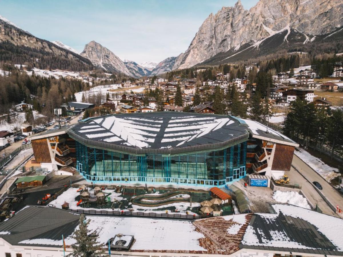 The Cortina Curling Olympic Stadium, located in front of the Dolomites